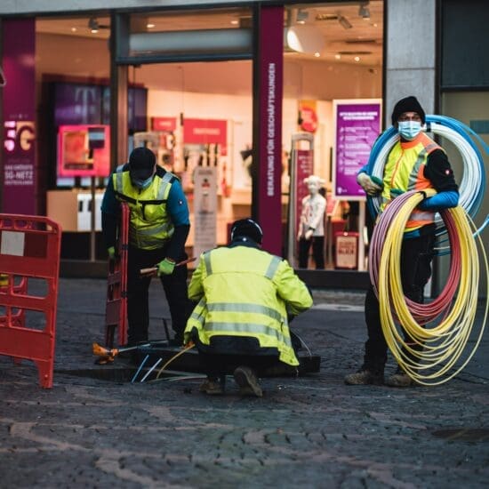 Technicians installing empty pipes for fiber internet in a city.
