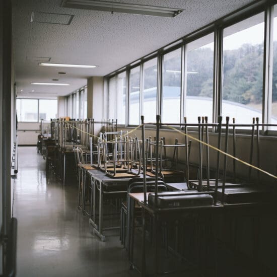 Chairs stacked on tables in an empty classroom.