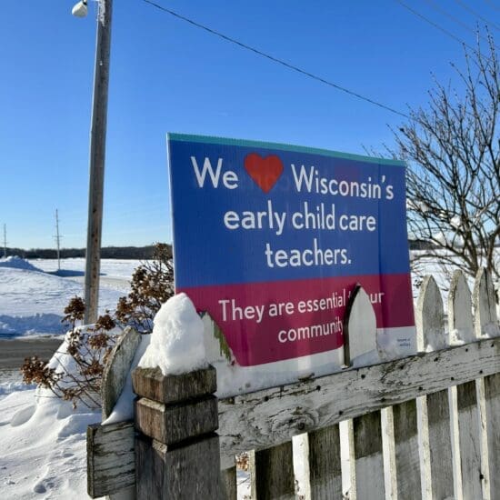 A sign supporting child care workers is perched on the fence outside Future All Star's Academy daycare in Juneau, WI, on Jan. 16.