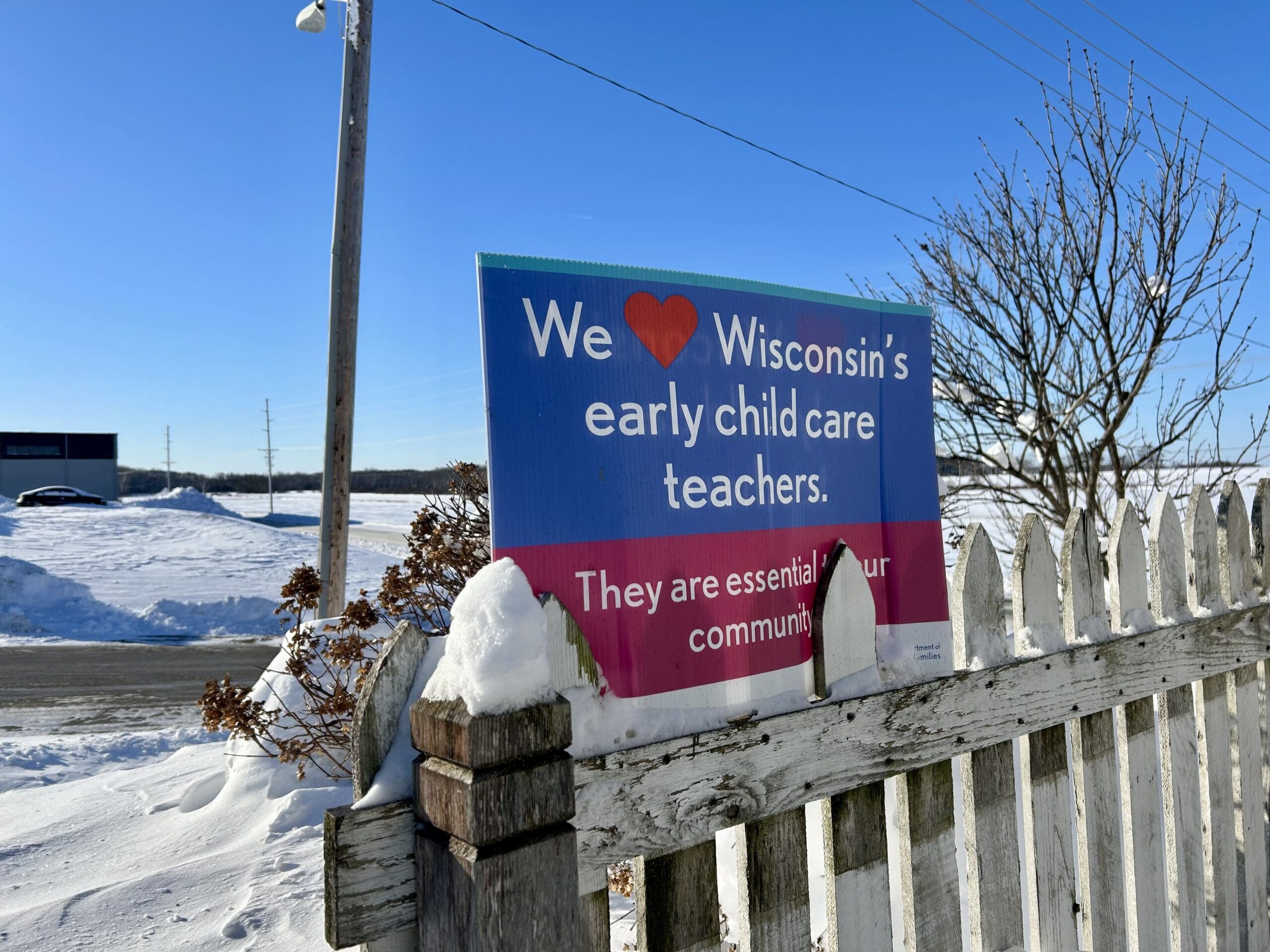 A sign supporting child care workers is perched on the fence outside Future All Star's Academy daycare in Juneau, WI, on Jan. 16.