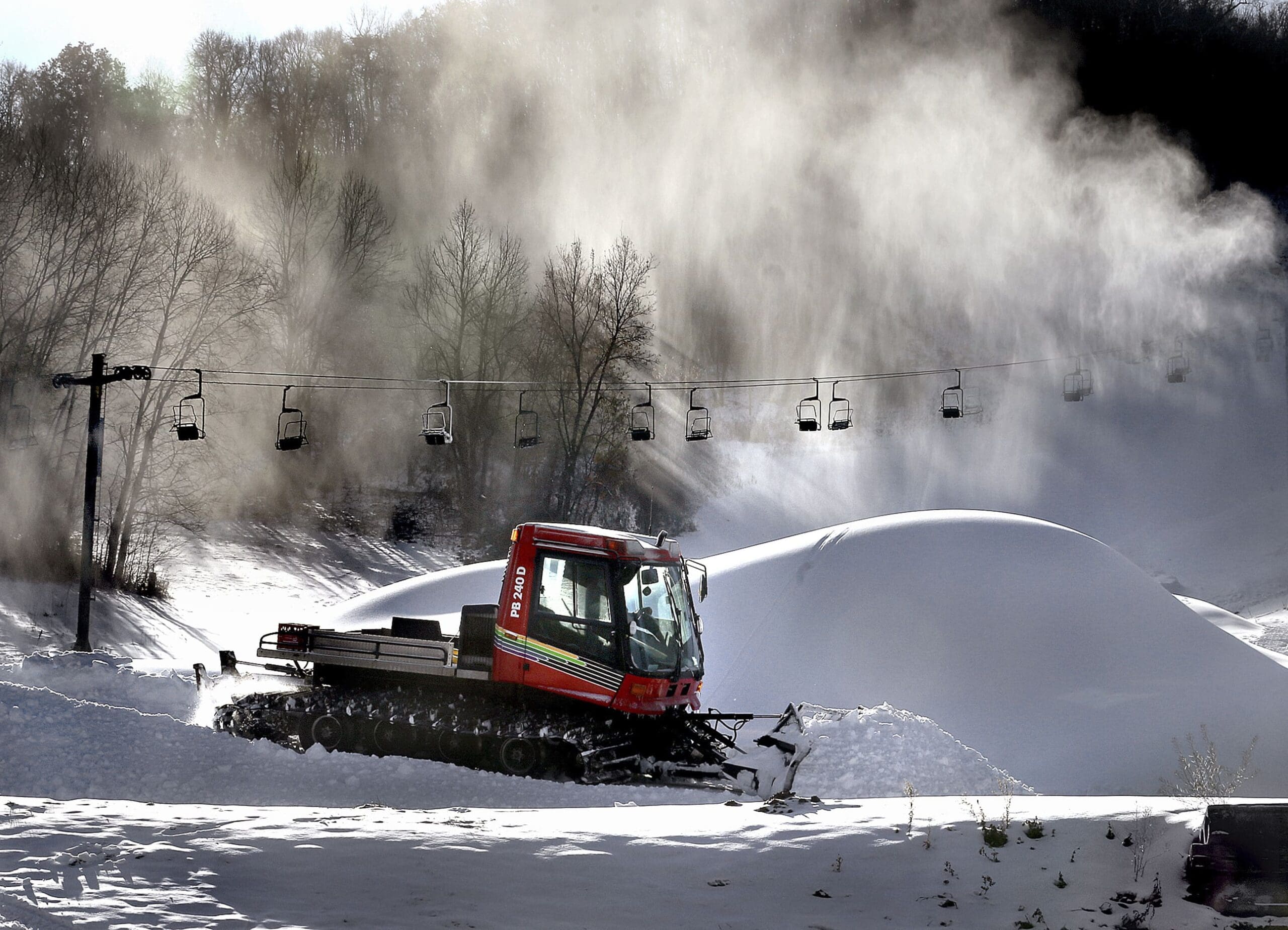 Snow billows from a snowmaker, Tuesday, Nov. 12, 2019, creating piles as Tom Roesler, mountain manager at Mount La Crosse in La Crosse, WI, spreads it out.