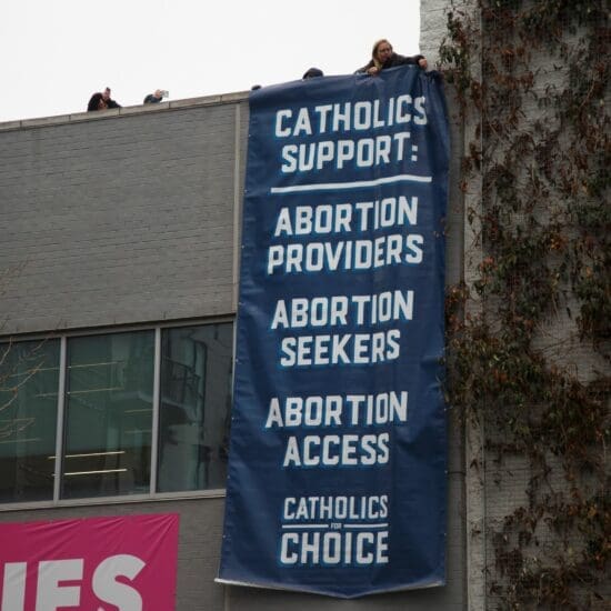 Pro-abortion rights activists drop a banner from a building during a protest against abortion outside of the Carol Whitehall Moses Center Planned Parenthood office in Washington, D.C. on January 19, 2023.
