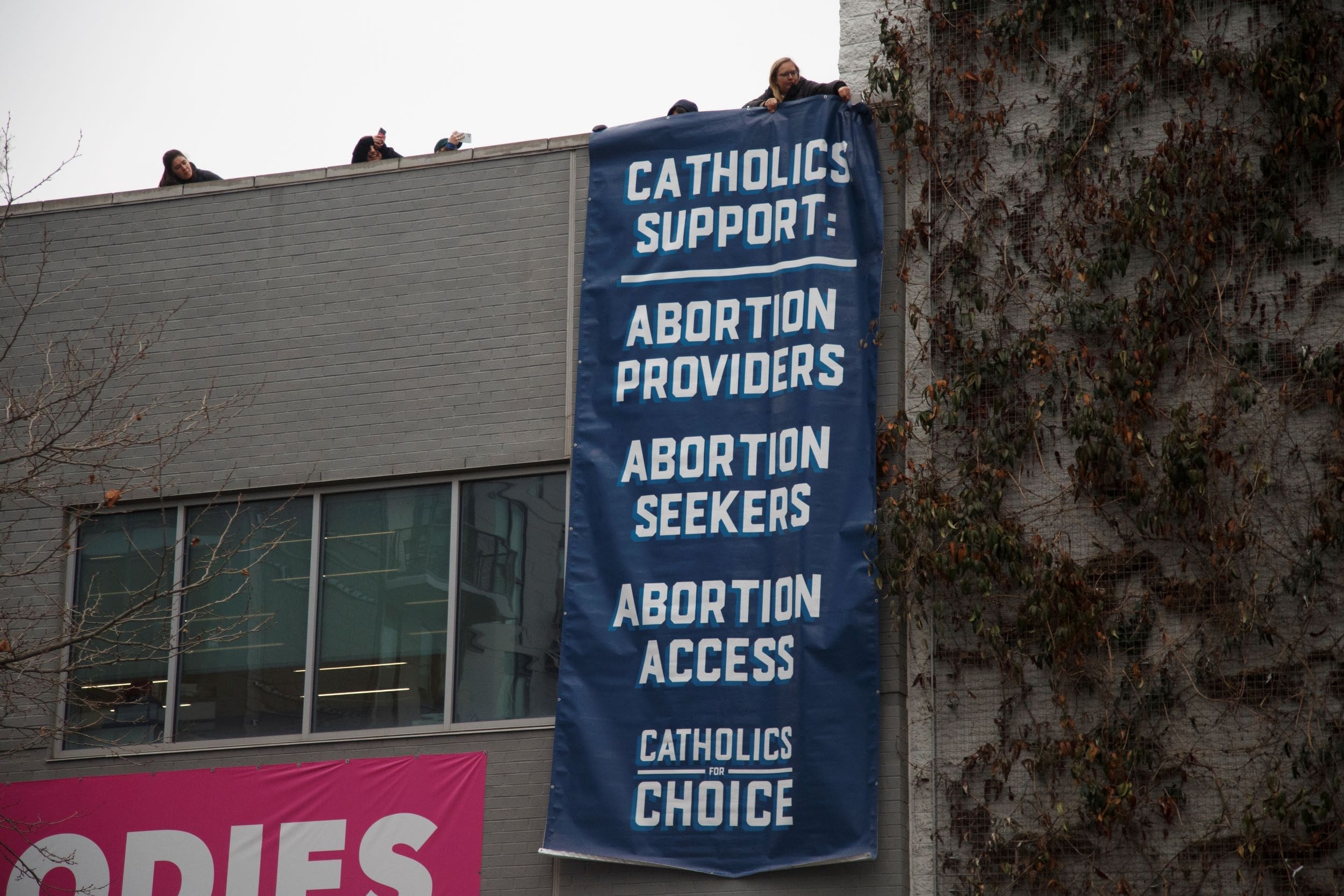 Pro-abortion rights activists drop a banner from a building during a protest against abortion outside of the Carol Whitehall Moses Center Planned Parenthood office in Washington, D.C. on January 19, 2023.